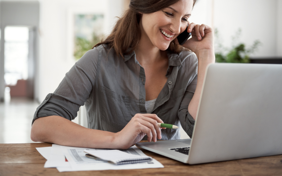 Person working at a desk, reviewing her administrative assistant resume summary.