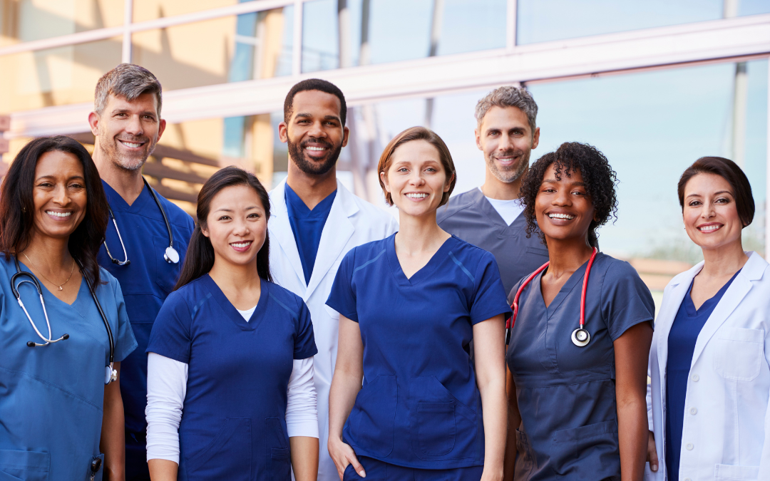 Nurses standing together smiling after updating their nursing resume summary and landing their dream job.